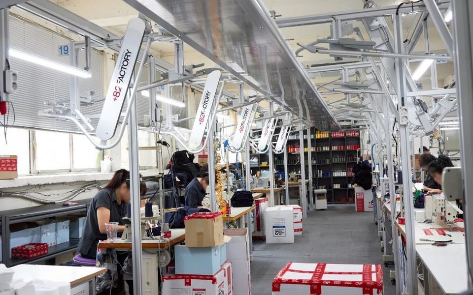+82FACTORY 봉제 라인 — 천장 행거 반송 시스템과 재봉 작업대